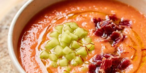 Plato hondo con salmorejo de melón amarillo decorado con hebras de azafrán Antonio Sotos, crujiente de jamón ibérico y un hilo de aceite de oliva.